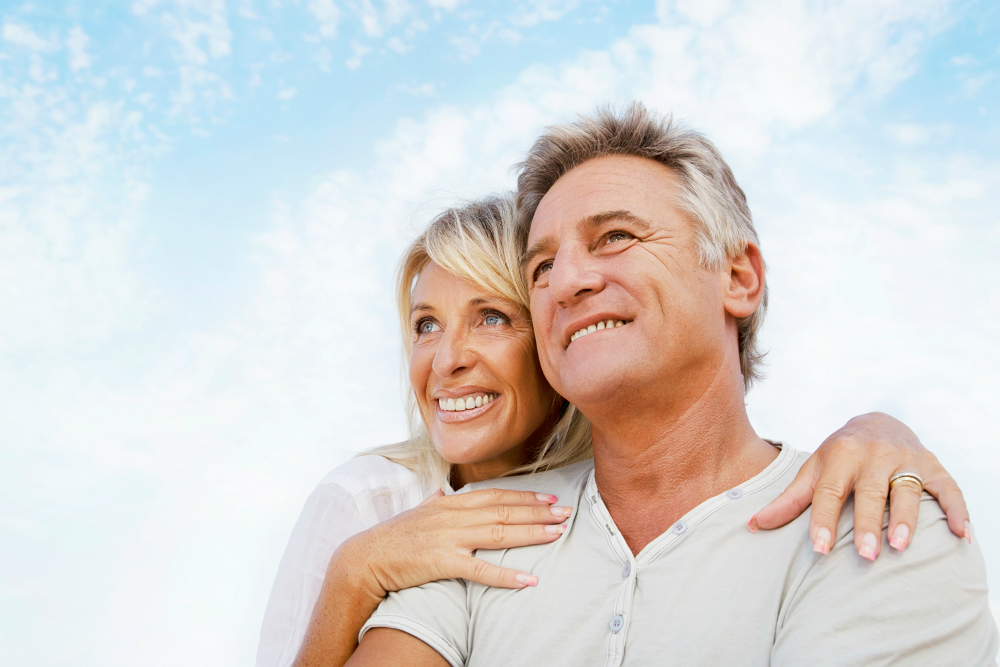 A couple smiling together, relaxed and confident about their dental care